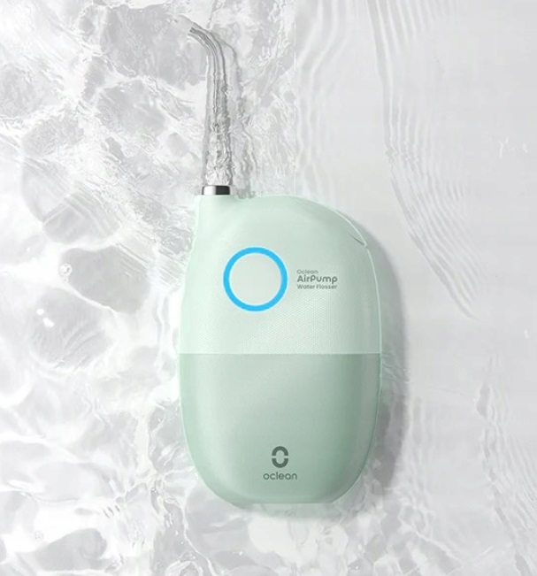 Zielony i biały irygator z strumieniami wody i niebieskim światłem.