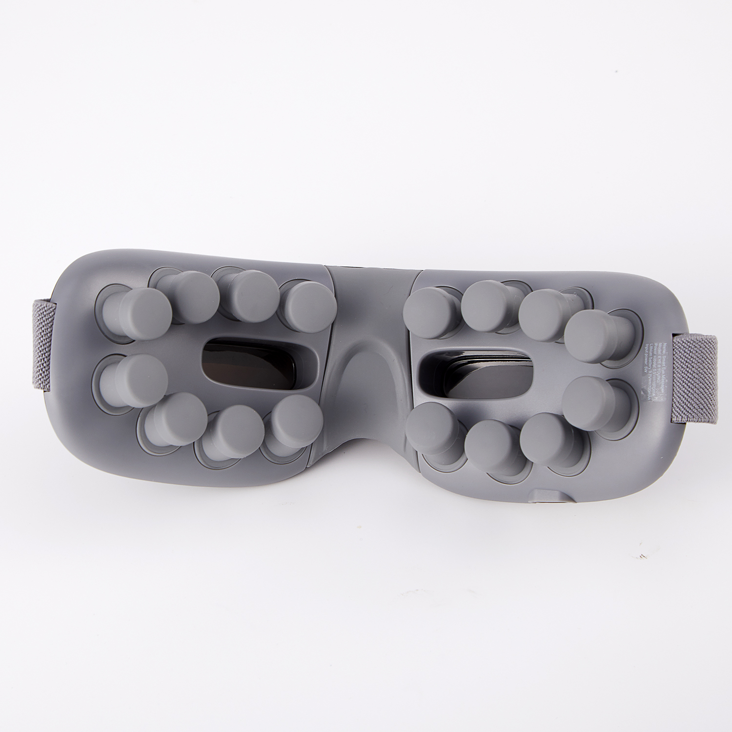 Gray eye massager with round nubs, strap, and eye holes, on white background.