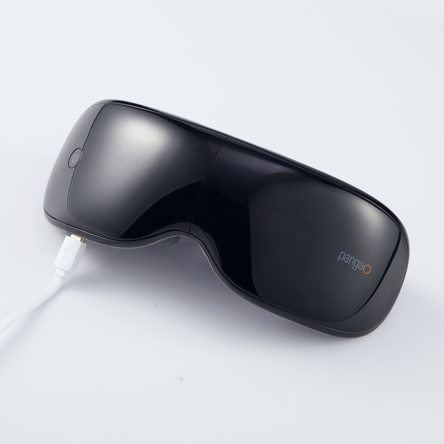 Black eye massager with a white USB cable. The product is on a white surface.