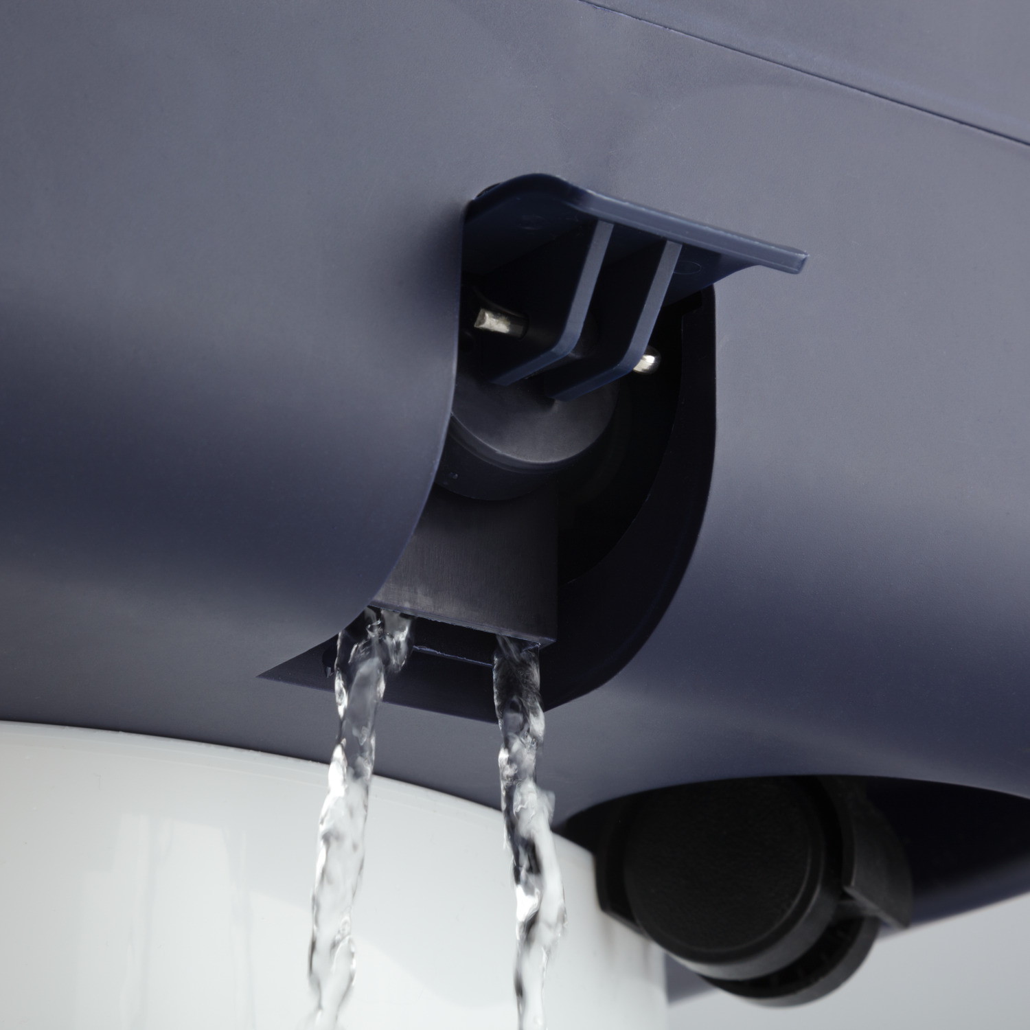 Water stroomt uit een donkerblauw apparaat. Het water stroomt naar beneden. De achtergrond is wit.