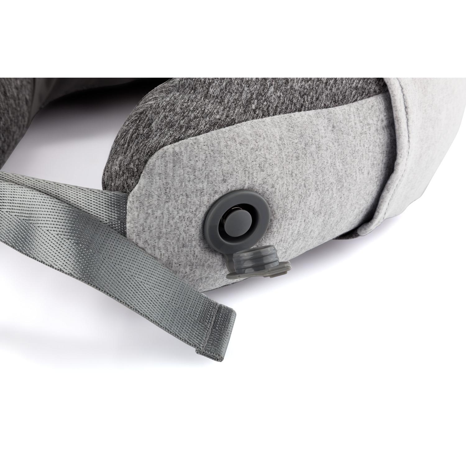 Close-up of a gray travel pillow with a strap, button, and fabric texture.