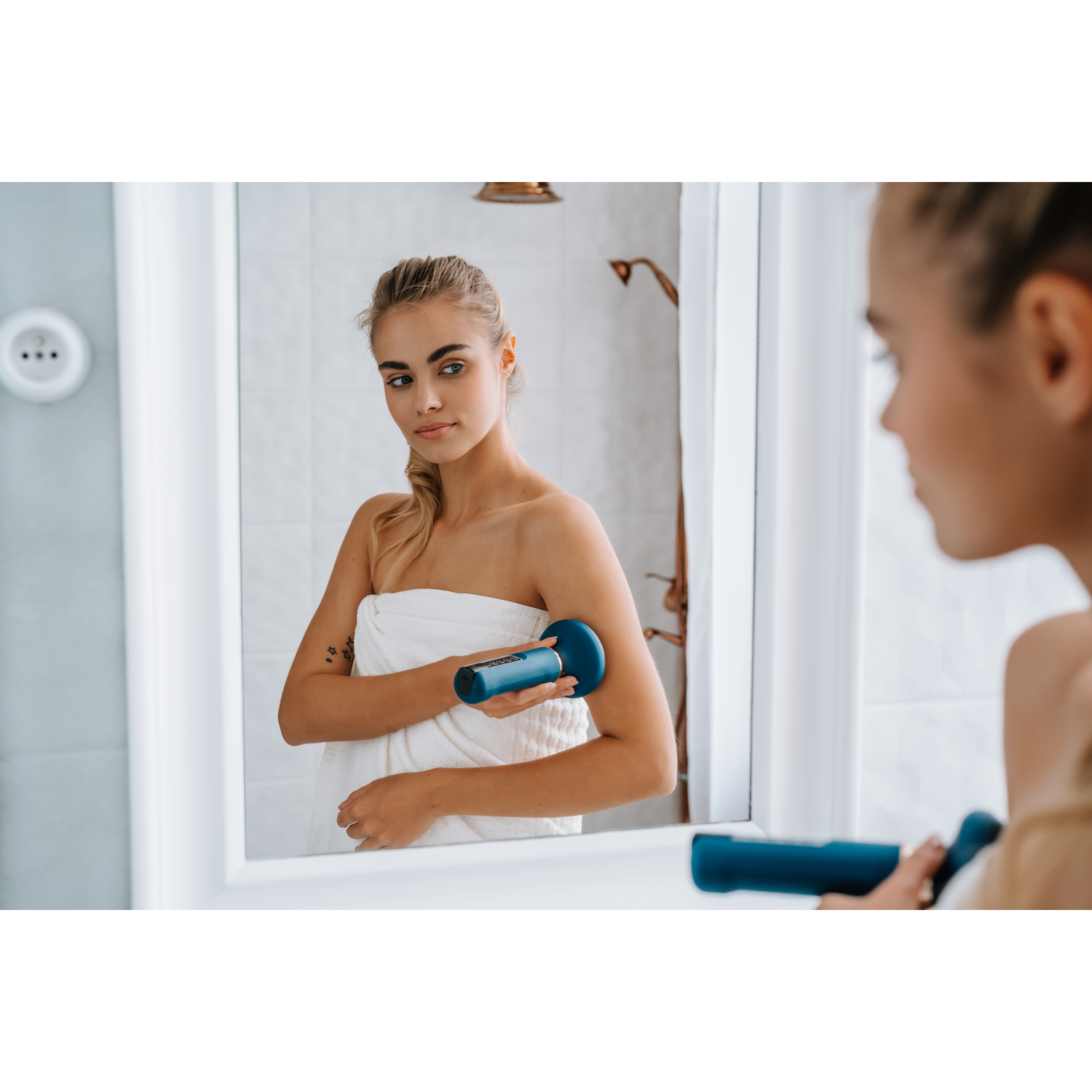 A woman using a blue facial massage tool.