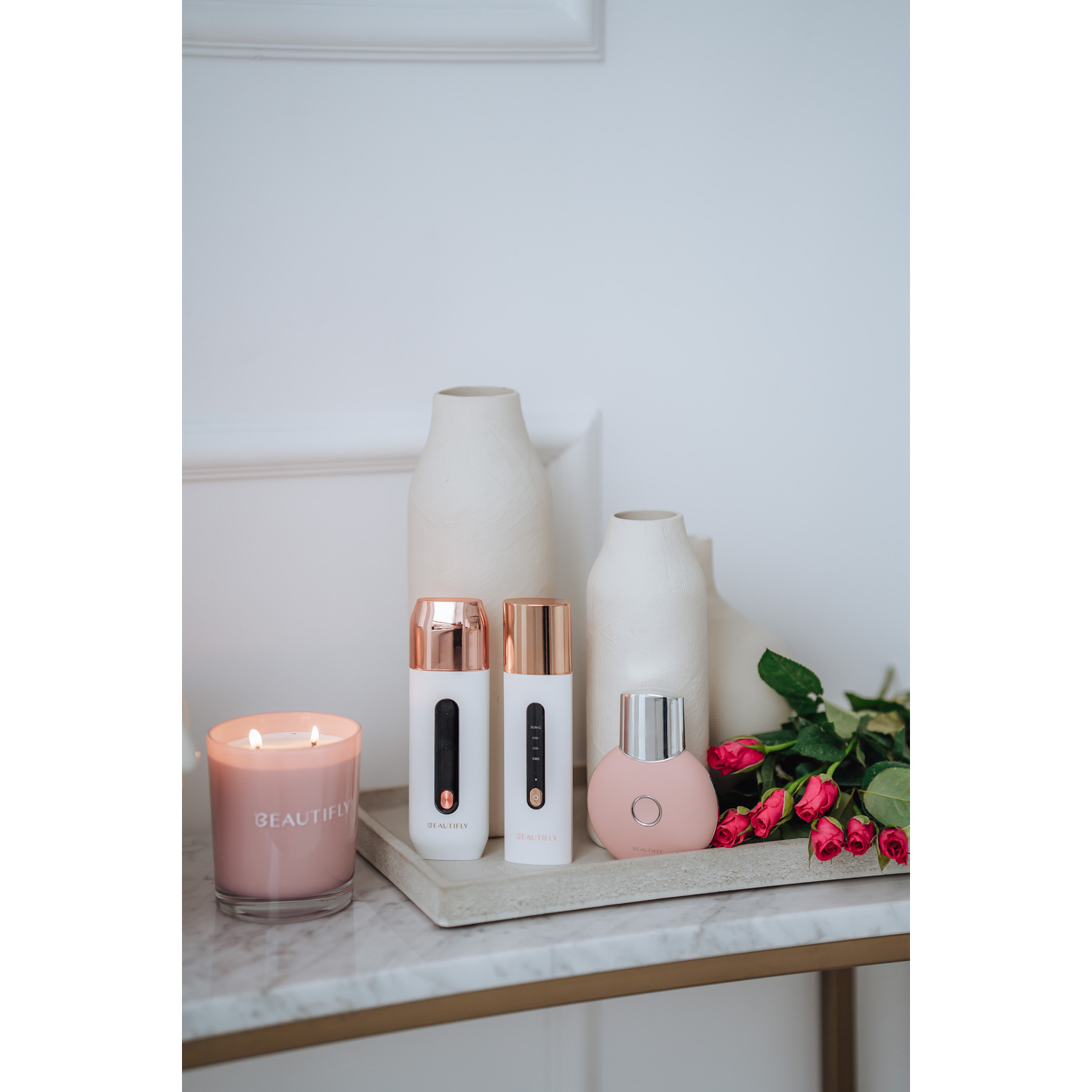 Un outil de beauté blanc avec des accents dorés est présenté.