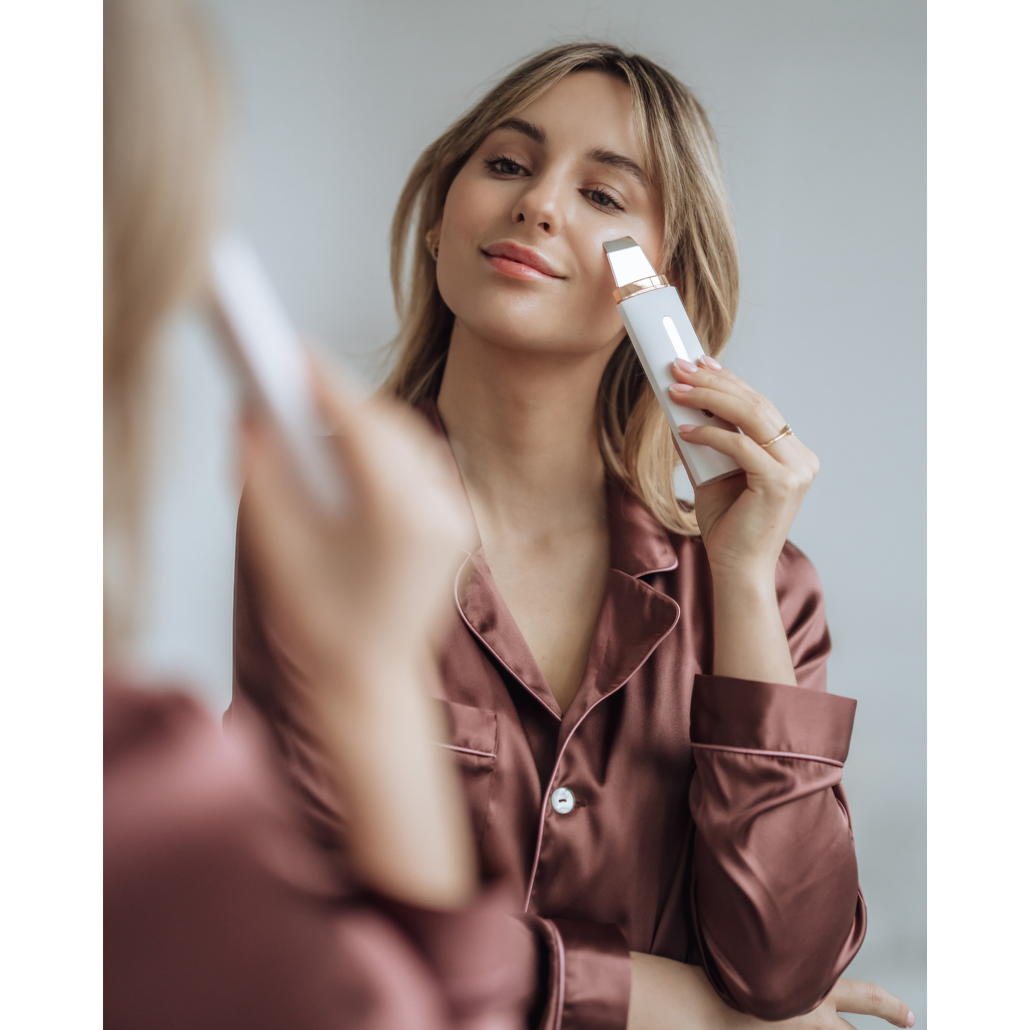 Nettoyeur de pores facial blanc et or rose, avec têtes détachables.