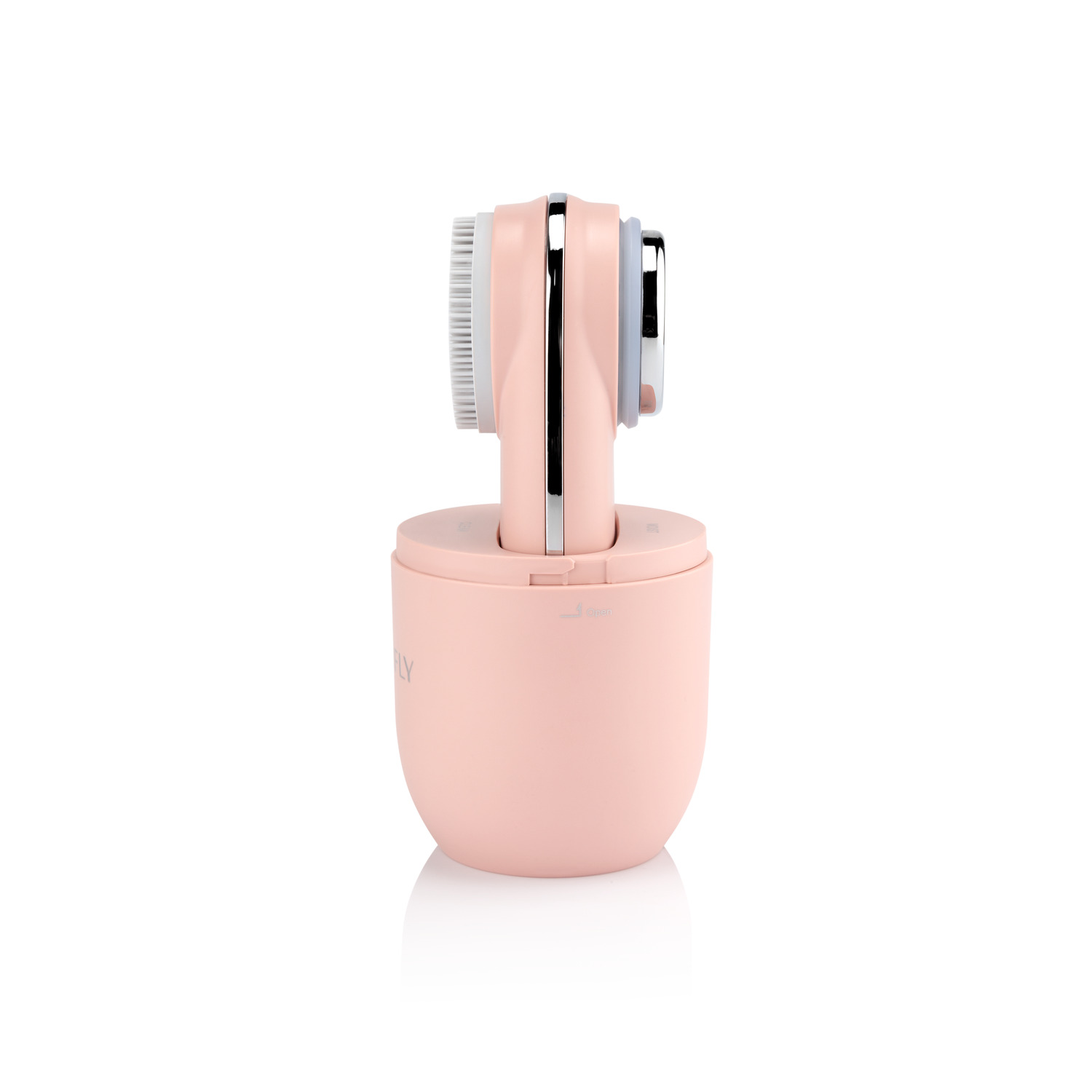 A pink facial cleansing brush on a white surface.