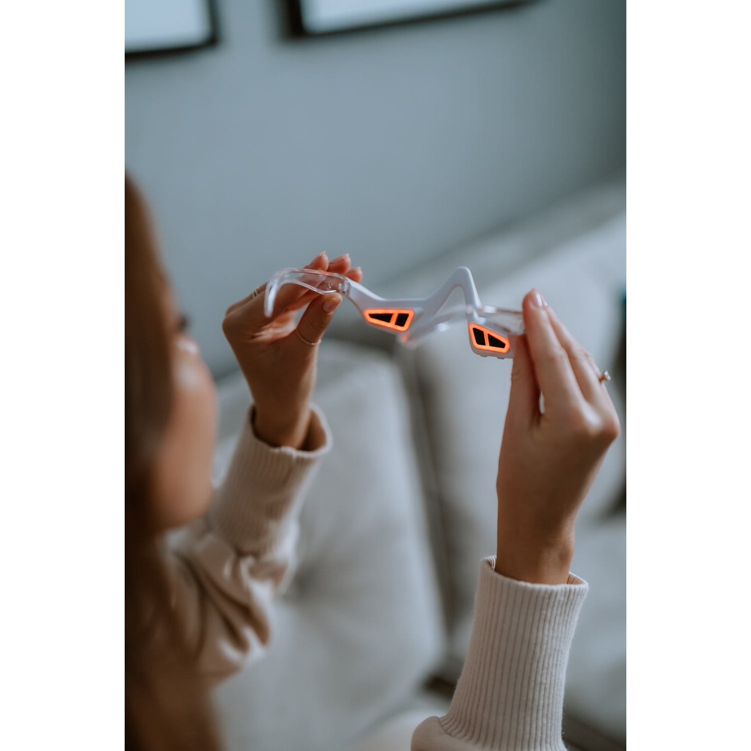 Person holding a clear frame with orange lights.