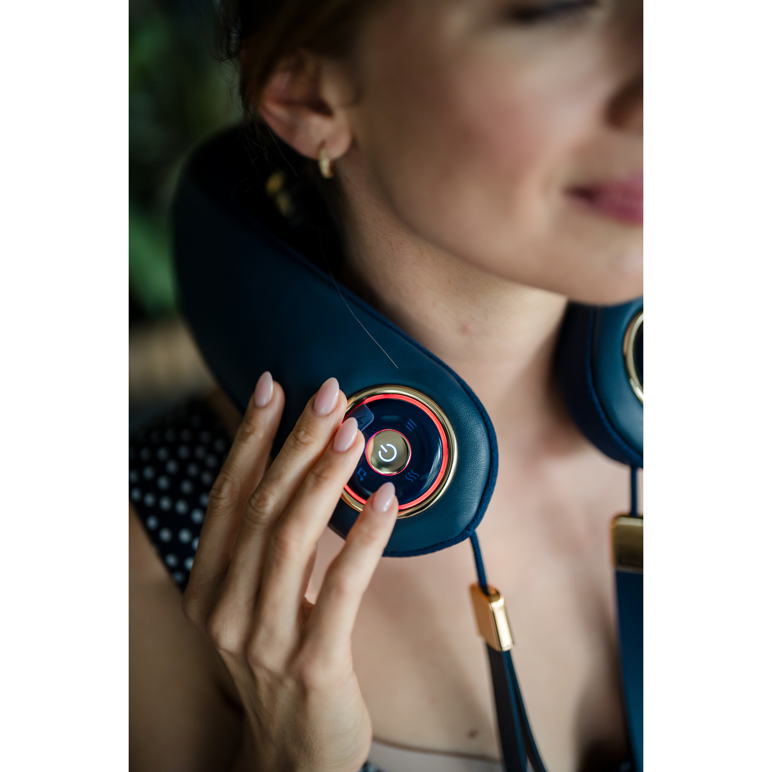 Close-up of a woman wearing a blue neck massager device.