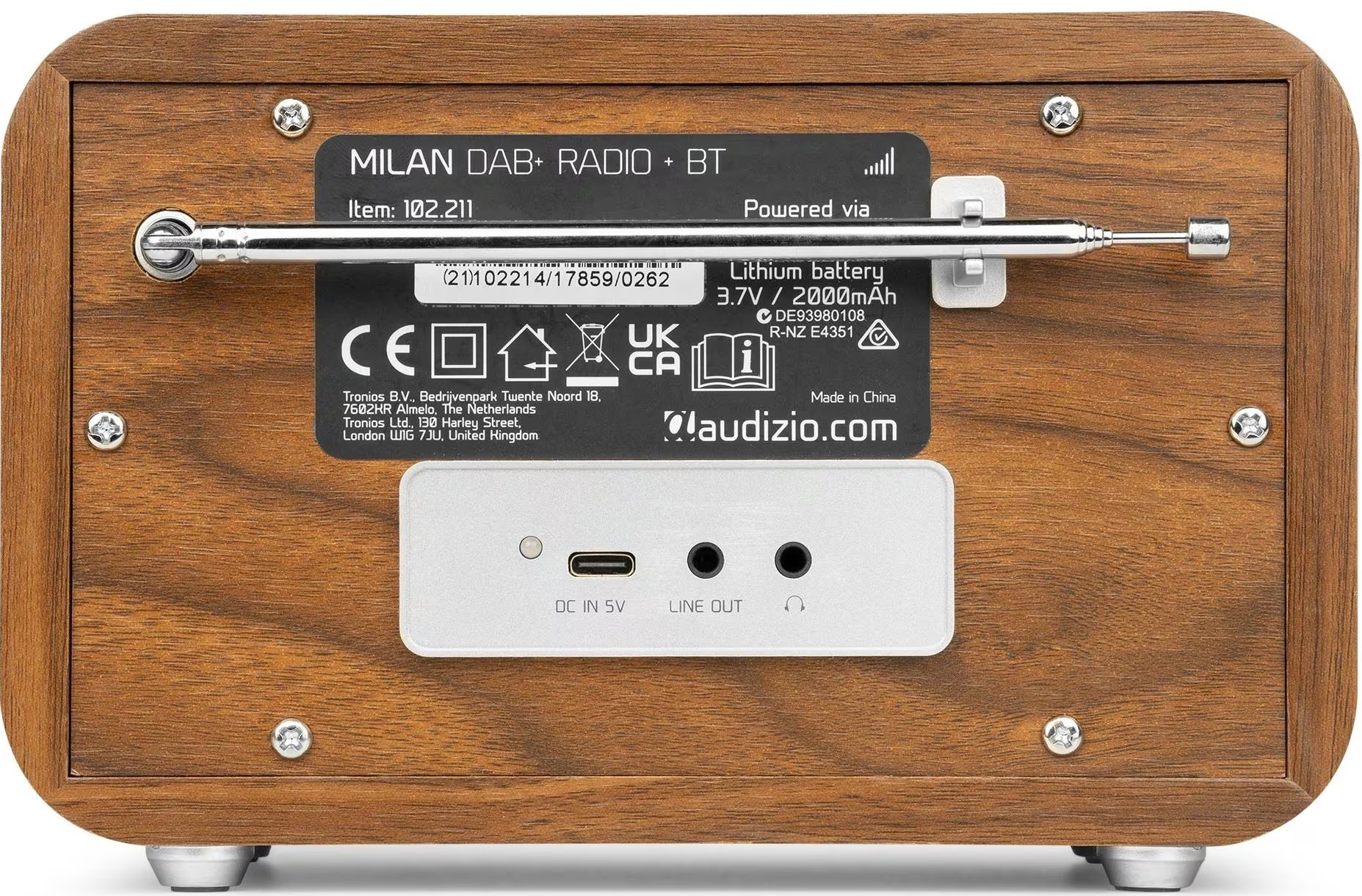 L'arrière d'une radio en bois avec étiquettes, entrées et antenne. Vis fixent le panneau.