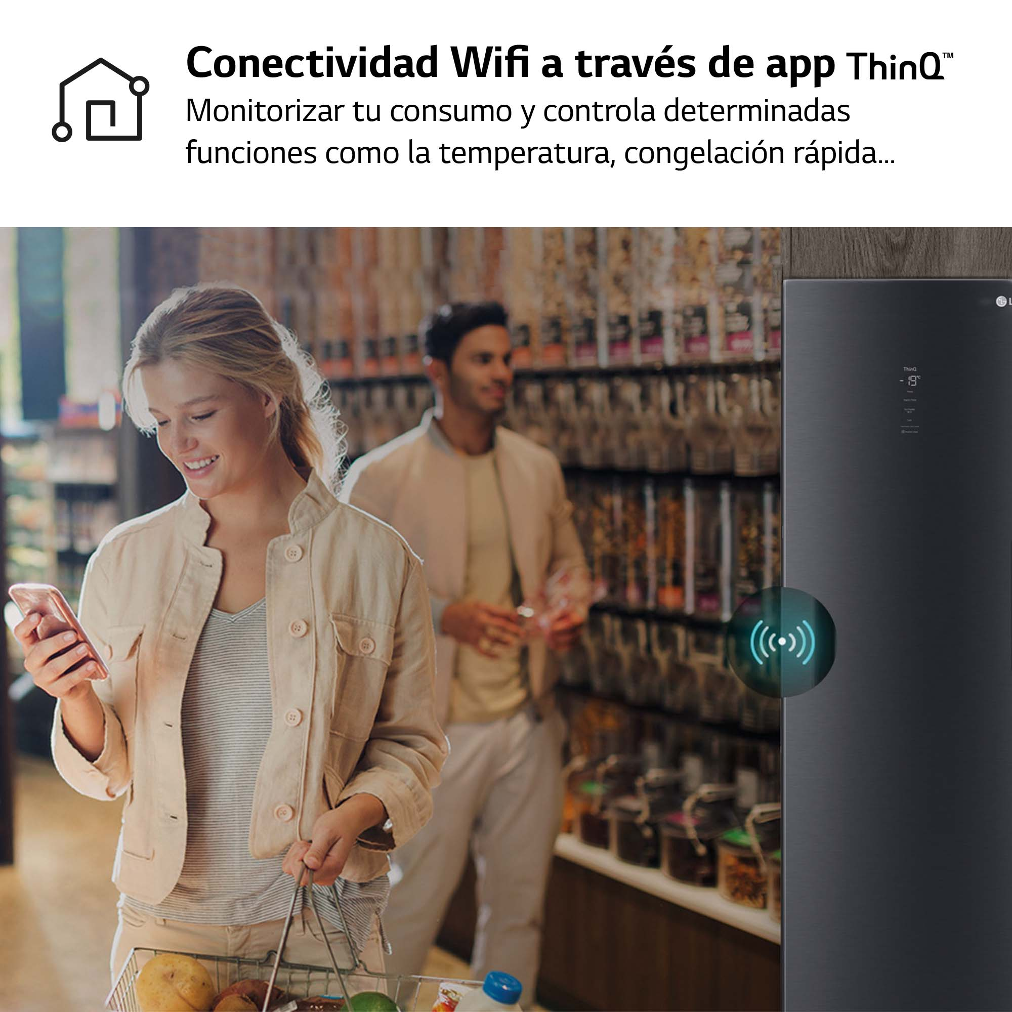 Mujer usando el teléfono en una tienda de comestibles, con un frigorífico LG al fondo.