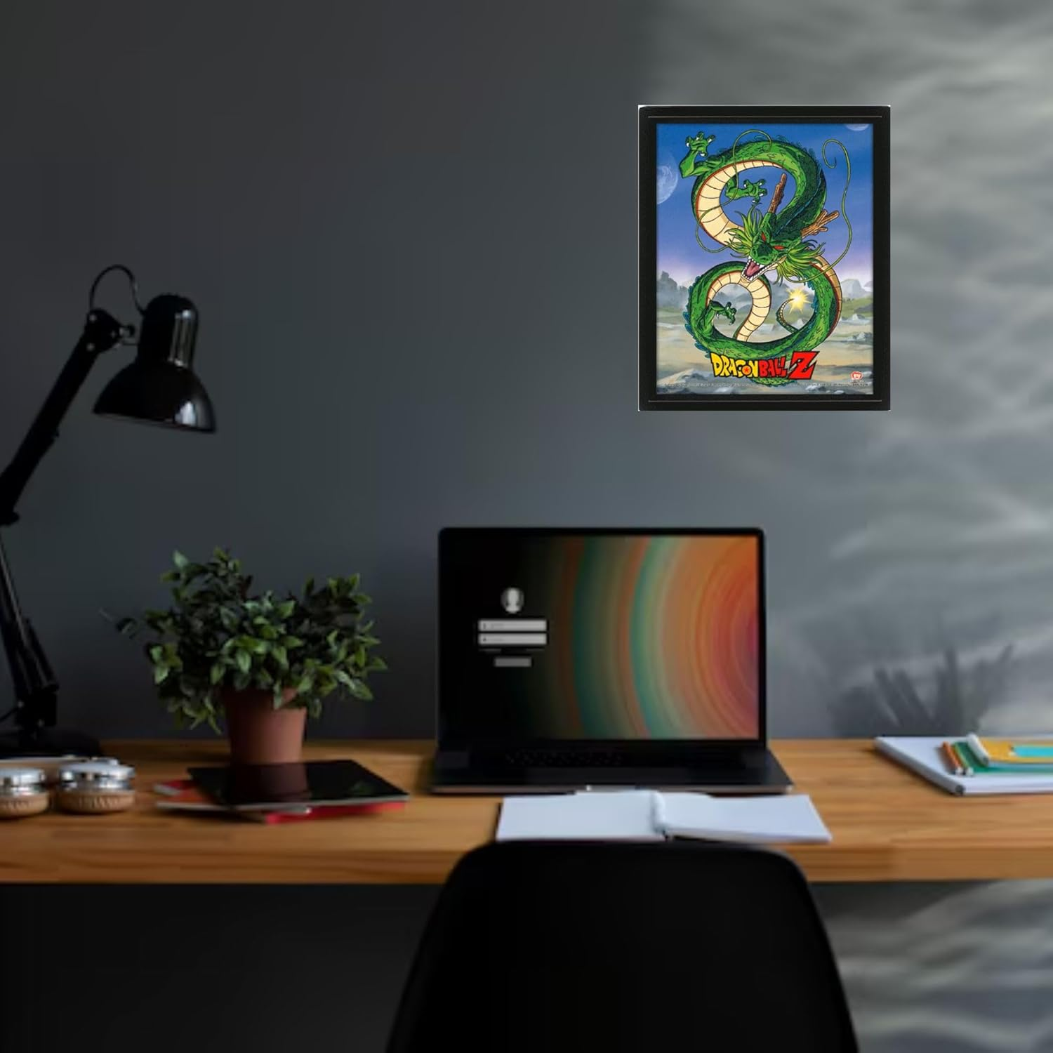 Un escritorio con una computadora portátil, una planta y un póster de Dragon Ball Z en la pared.