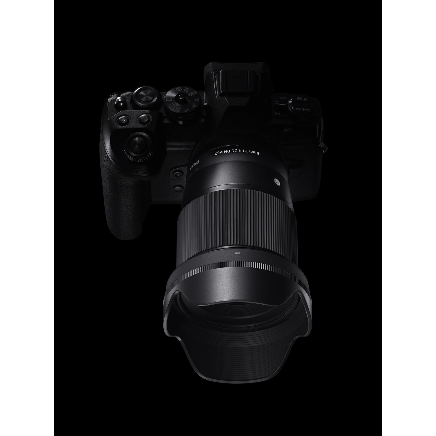 Fotocamera nera con obiettivo Sigma 16mm collegato. L'obiettivo ha ghiera di messa a fuoco e paraluce.