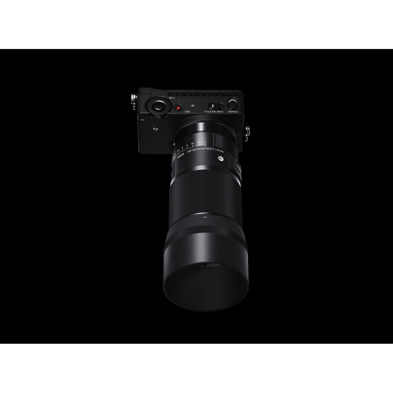Fotocamera nera con obiettivo grande su sfondo nero.