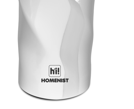 'hi! HOMENIST' metni olan beyaz, dokulu bir dekoratif eşyanın yakın çekimi.