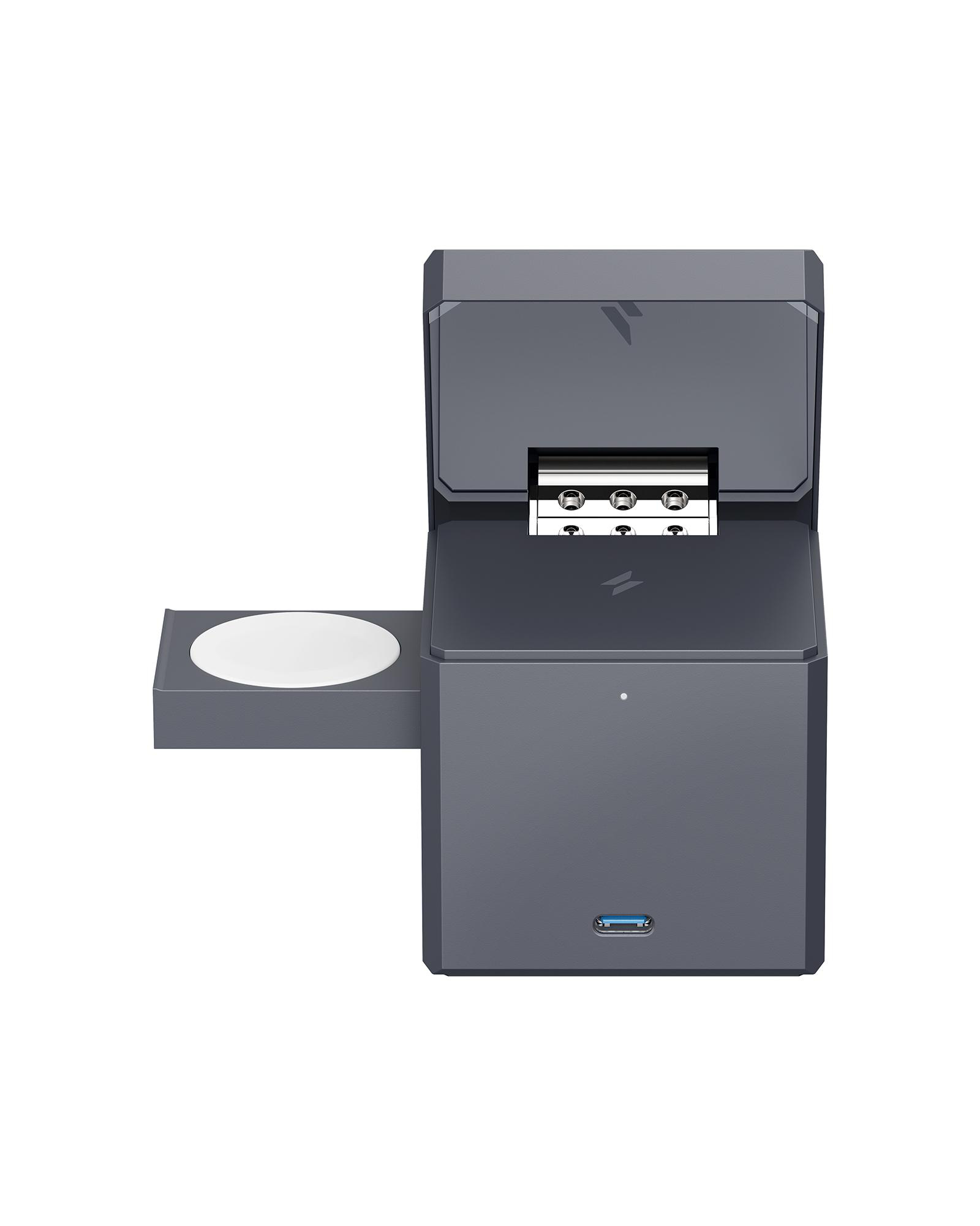 Graue Würfel-Ladestation mit Uhrenladegerät, offenem Deckel und USB-C-Anschluss.