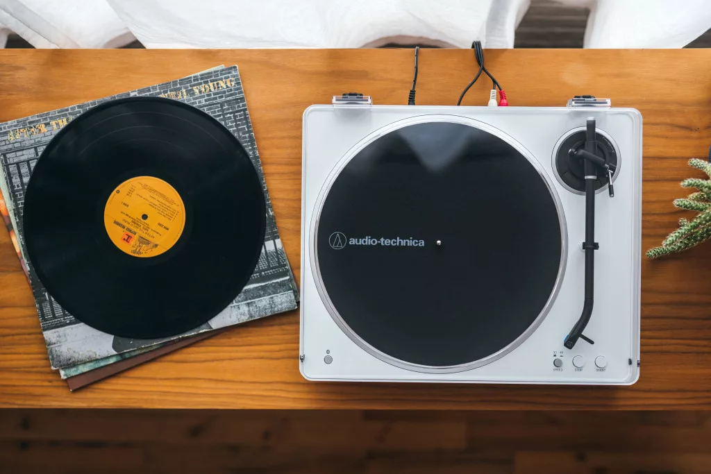 Felülnézet egy fehér lemezjátszóról fekete lemezzel és Audio-Technica logóval.