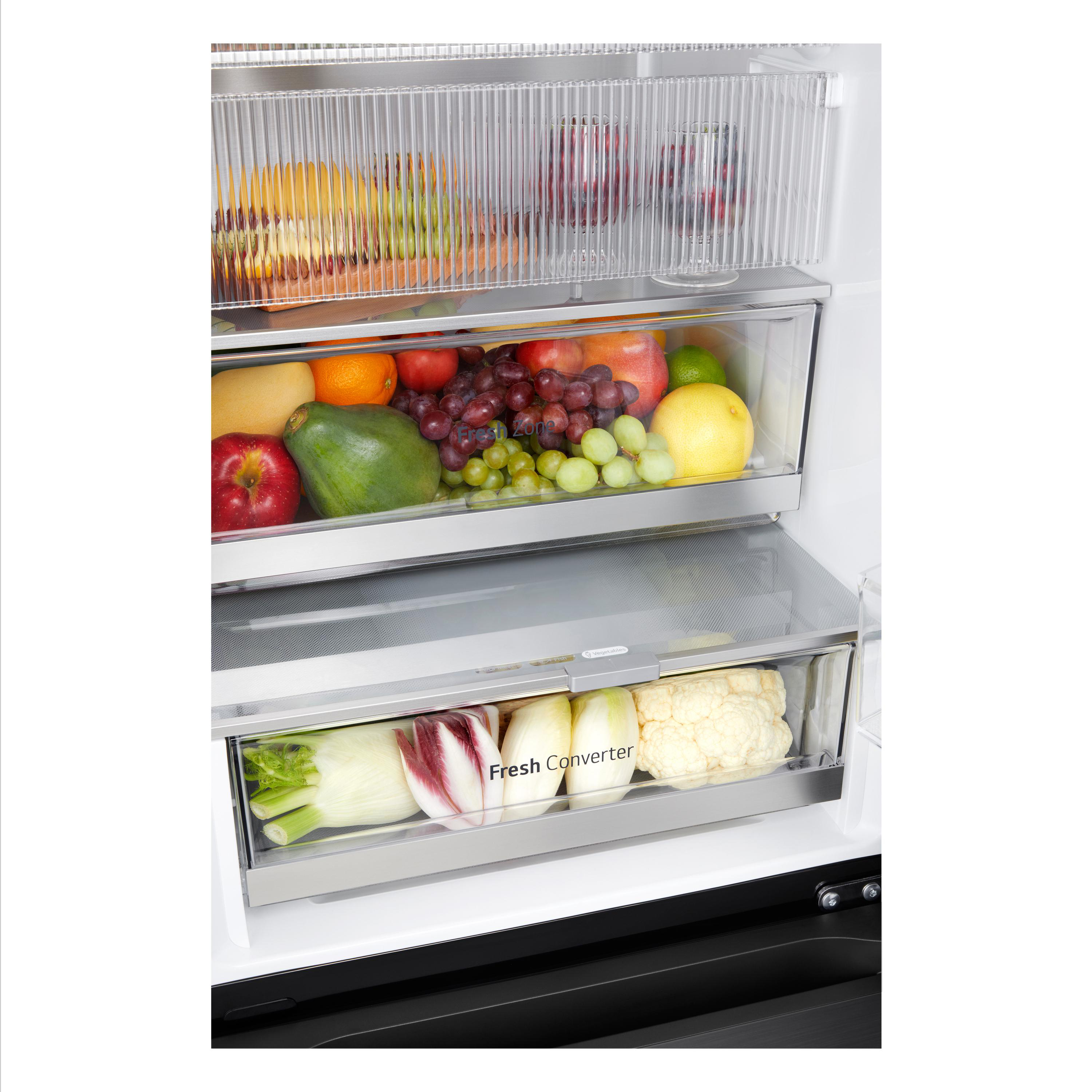 Geöffneter Kühlschrank mit Obst und Gemüse in Schubladen. Schwarzer Innenraum. Weißer Hintergrund.