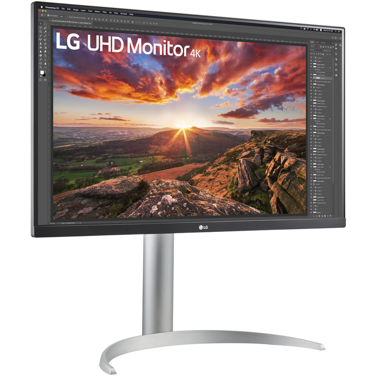 An LG UHD 4K monitor displays a sunset over a landscape. The monitor is on a silver stand, and the Photoshop interface is visible.