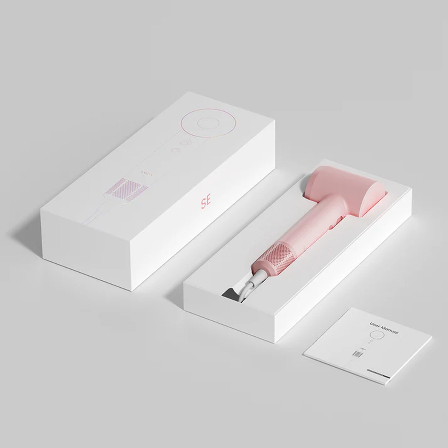 Asciugacapelli rosa all'interno di una scatola bianca. Viene mostrata anche un'altra scatola e un manuale utente.