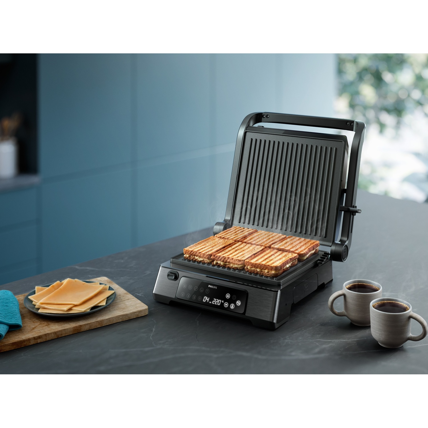 Griglia con quattro panini grigliati, tazze di caffè e formaggio.