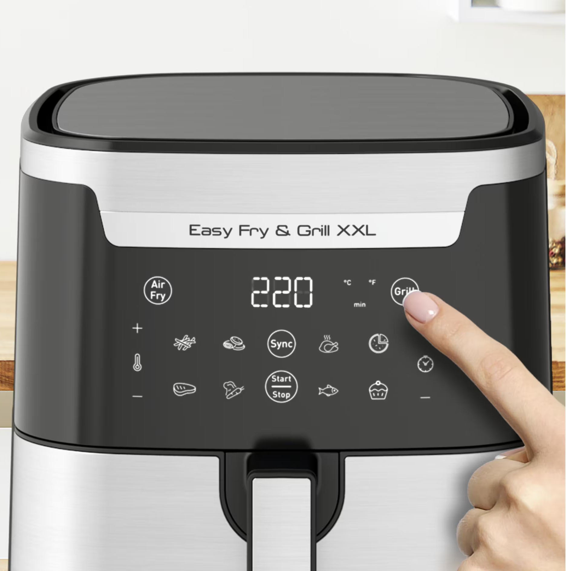 Friggitrice ad aria con display digitale, un dito tocca il pulsante grill. Sfondo: ambiente cucina.