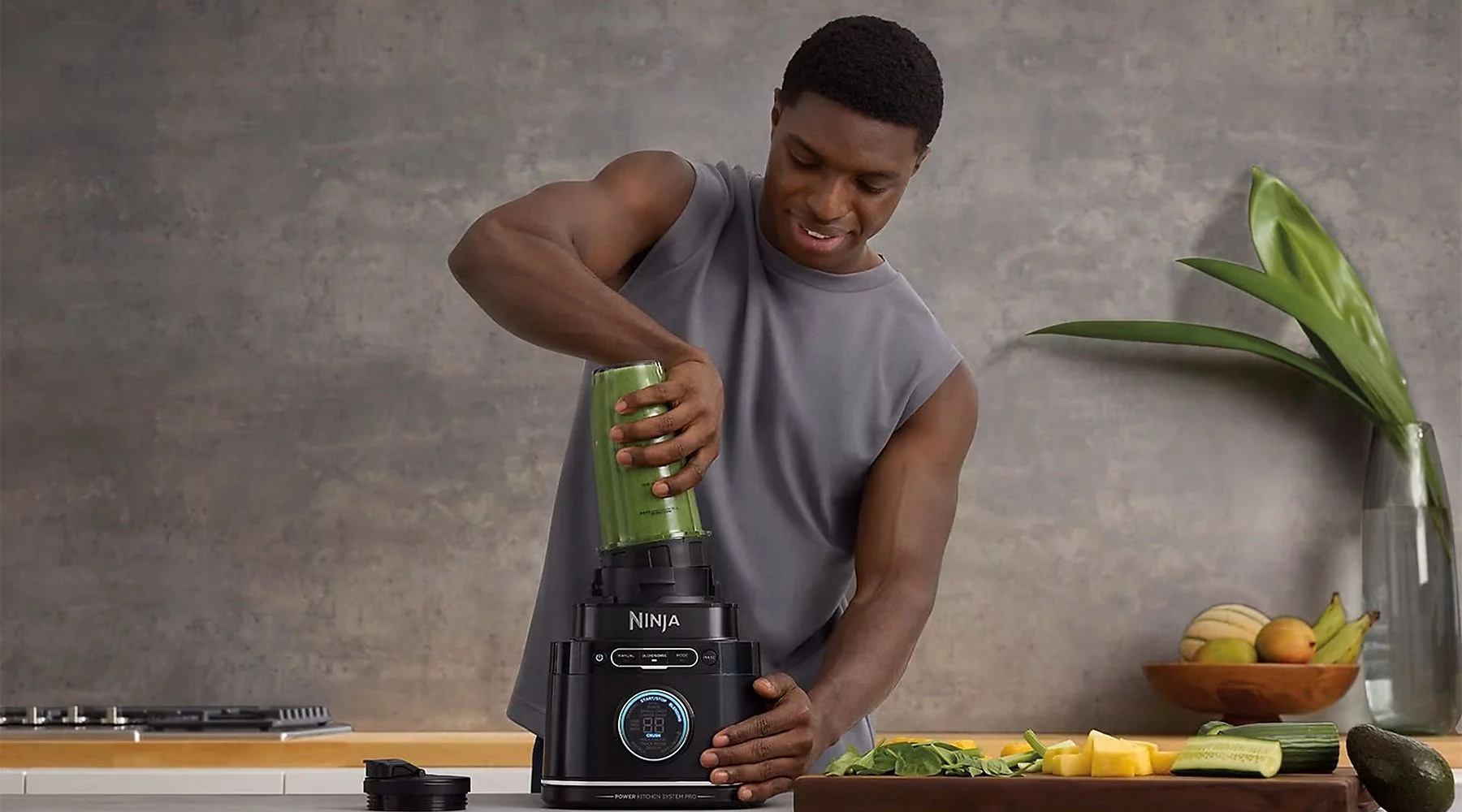 Férfi smoothie-t készít. Zöld smoothie-t önt a turmixgépbe.