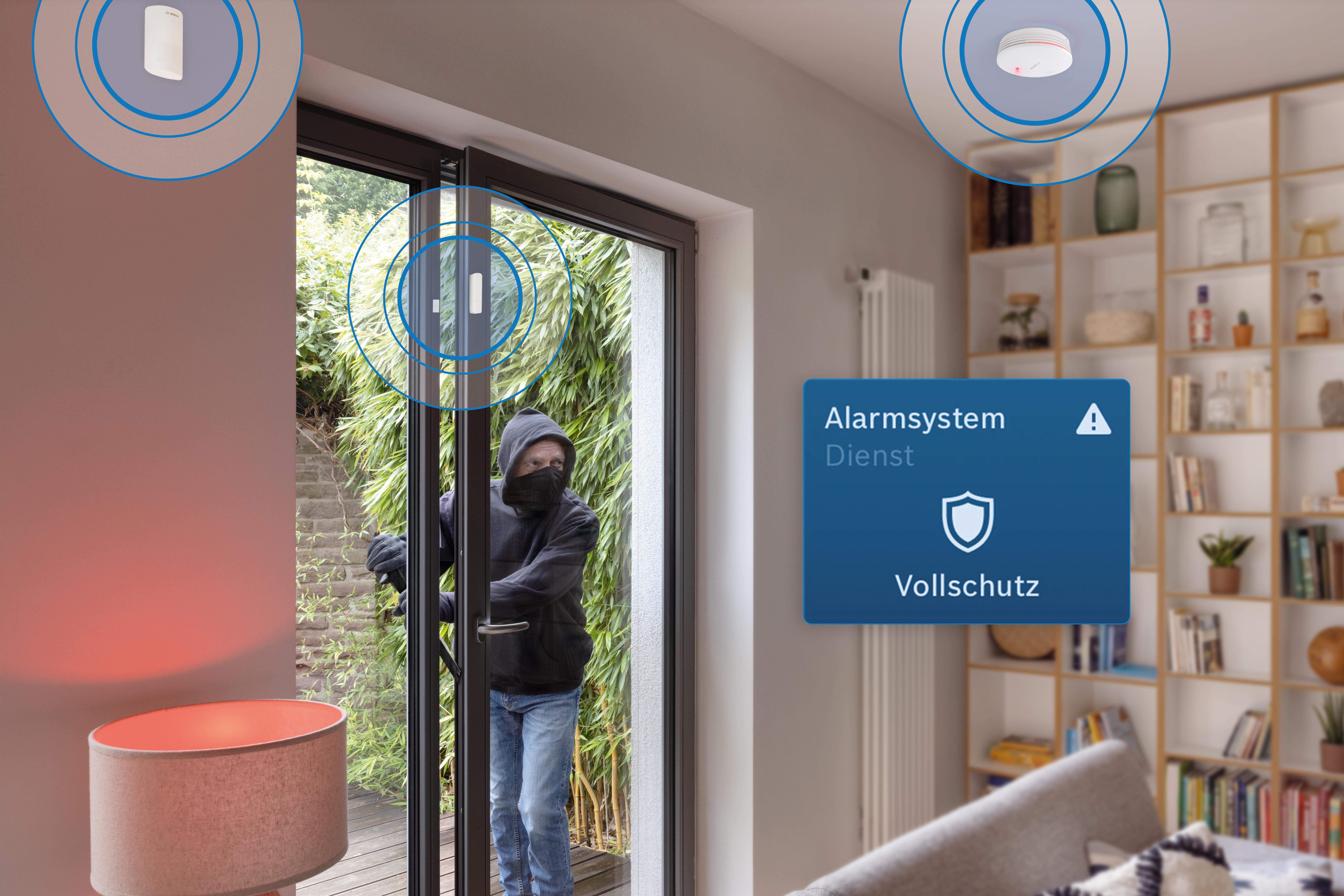 Ein Einbrecher mit Maske öffnet eine Tür. Benachrichtigung über Alarmanlage sichtbar.
