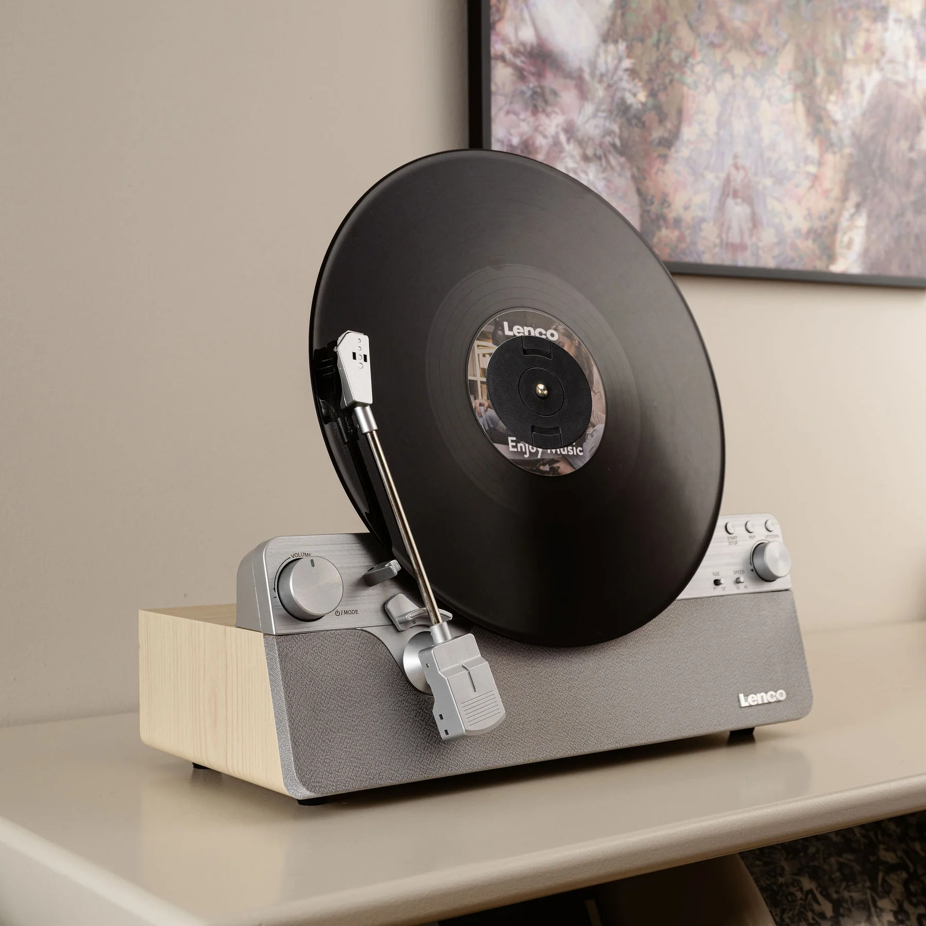 Une platine, disque noir avec la marque Lenco.