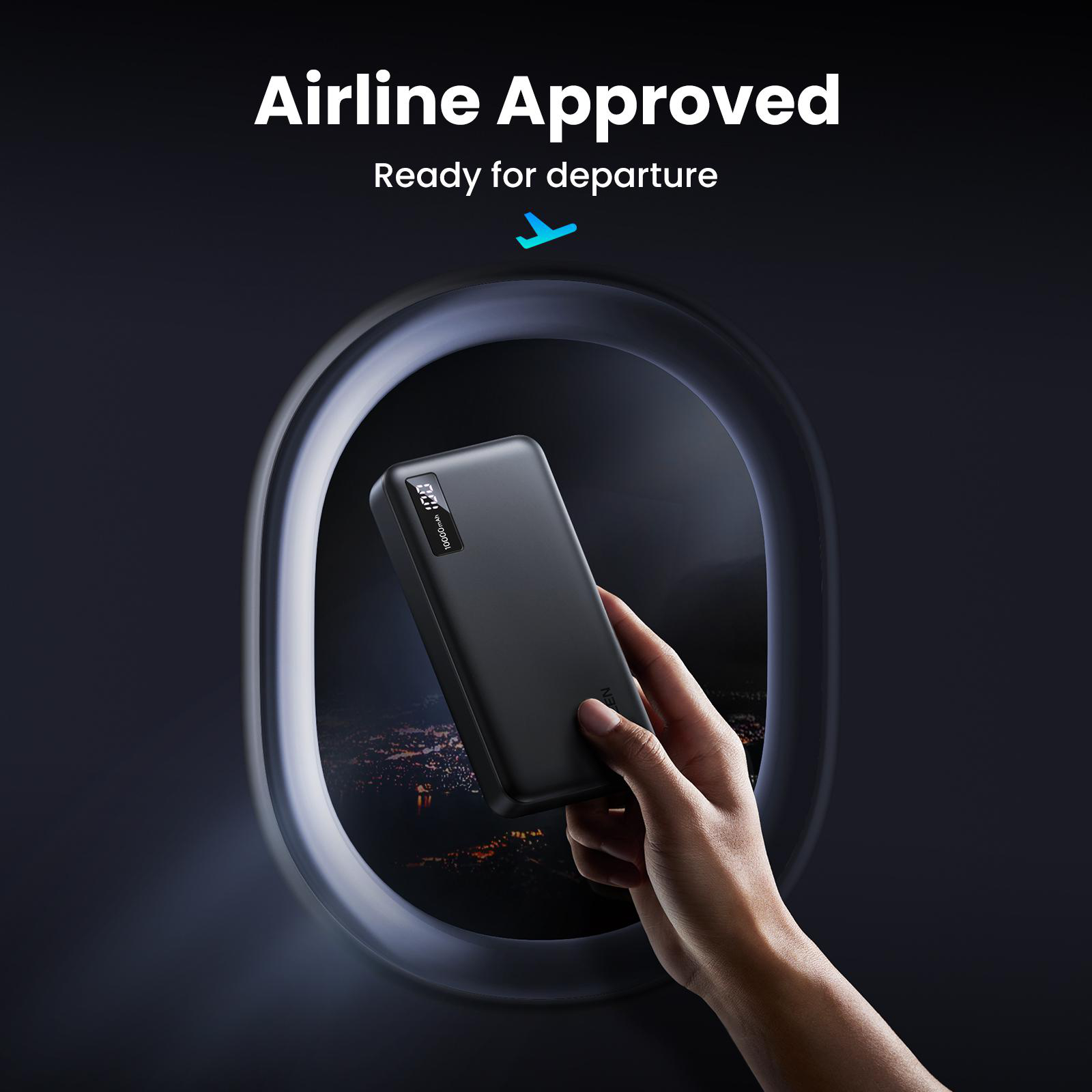 Hand hält schwarze Powerbank durch Flugzeugfenster.