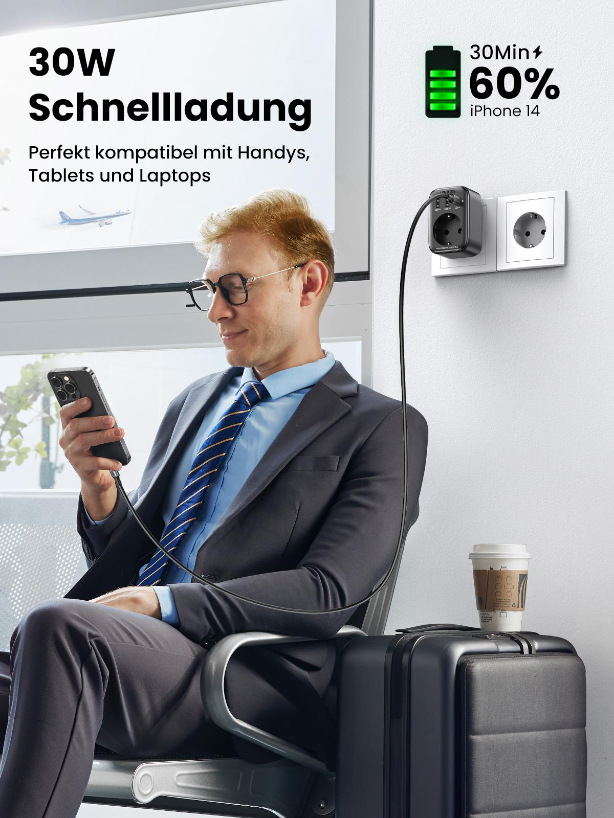 Ein Mann, der ein Telefon verwendet, das an ein Wandladegerät angeschlossen ist, mit Koffer.