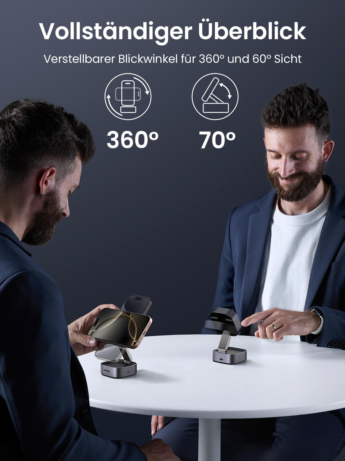 Zwei Männer mit einer Telefon-Ladestation auf einem Tisch, einer justiert den Winkel des Telefons.