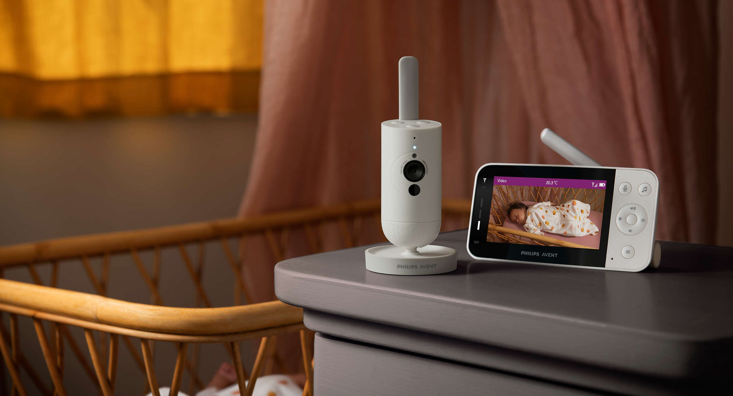 Ein Babyphone mit Kamera und Bildschirm auf einer Kommode.