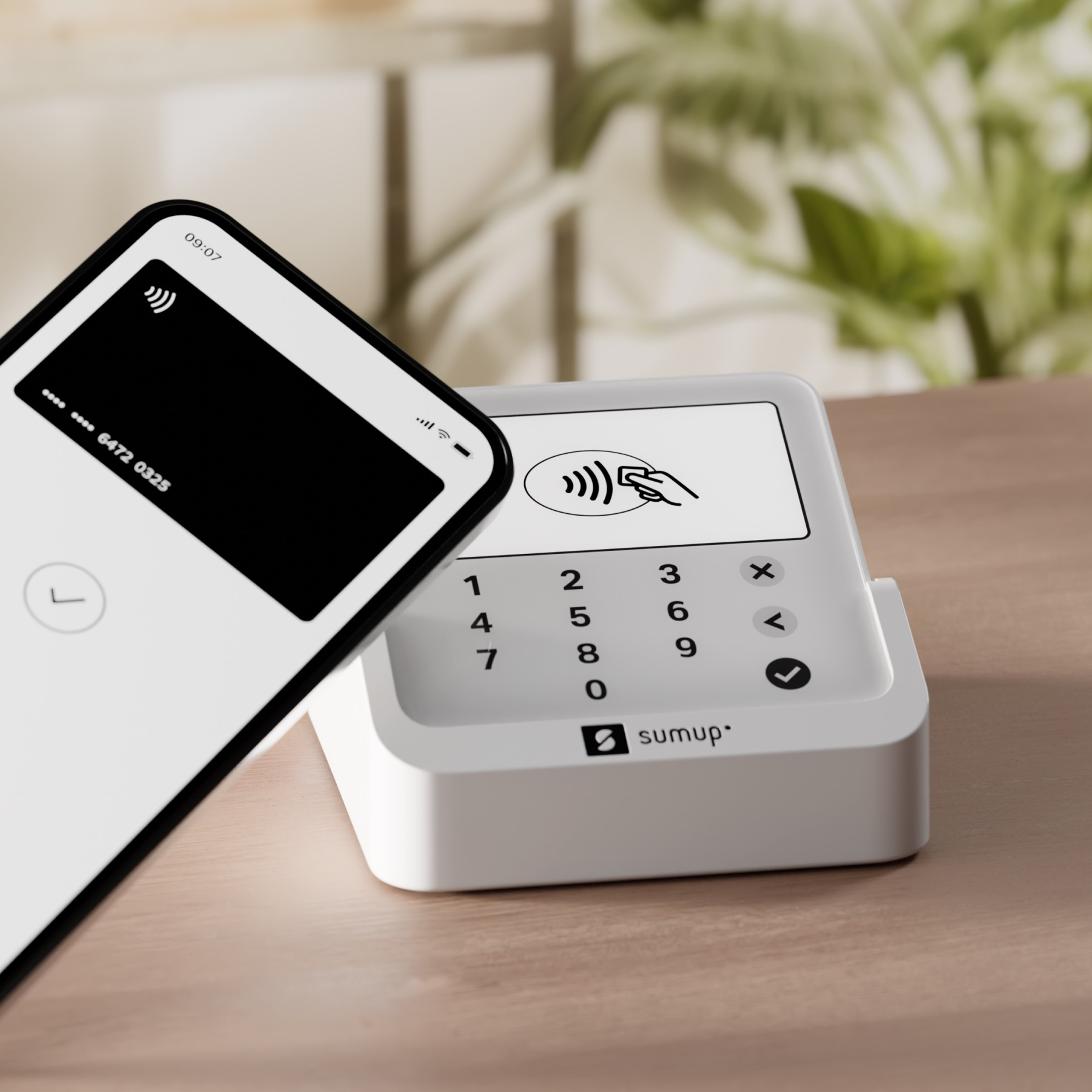 Smartphone con carta di credito vicino a un terminale di pagamento bianco.