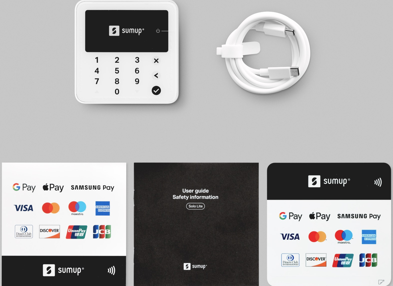 Lettore di carte Sumup bianco, cavo e letteratura su grigio.