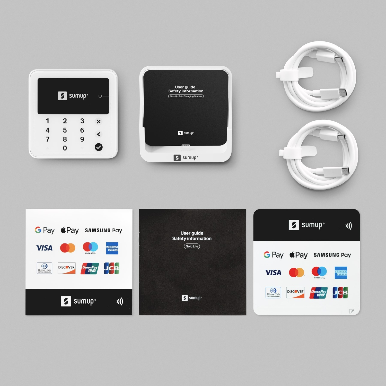Vari dispositivi e accessori Sumup sono esposti su una superficie bianca.
