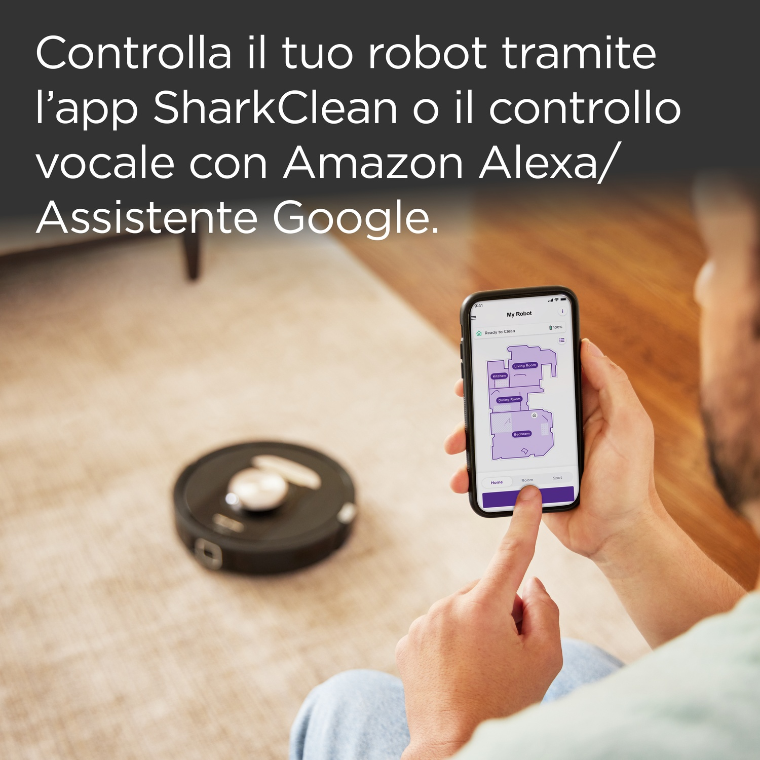 Una persona usa uno smartphone per controllare un robot aspirapolvere.