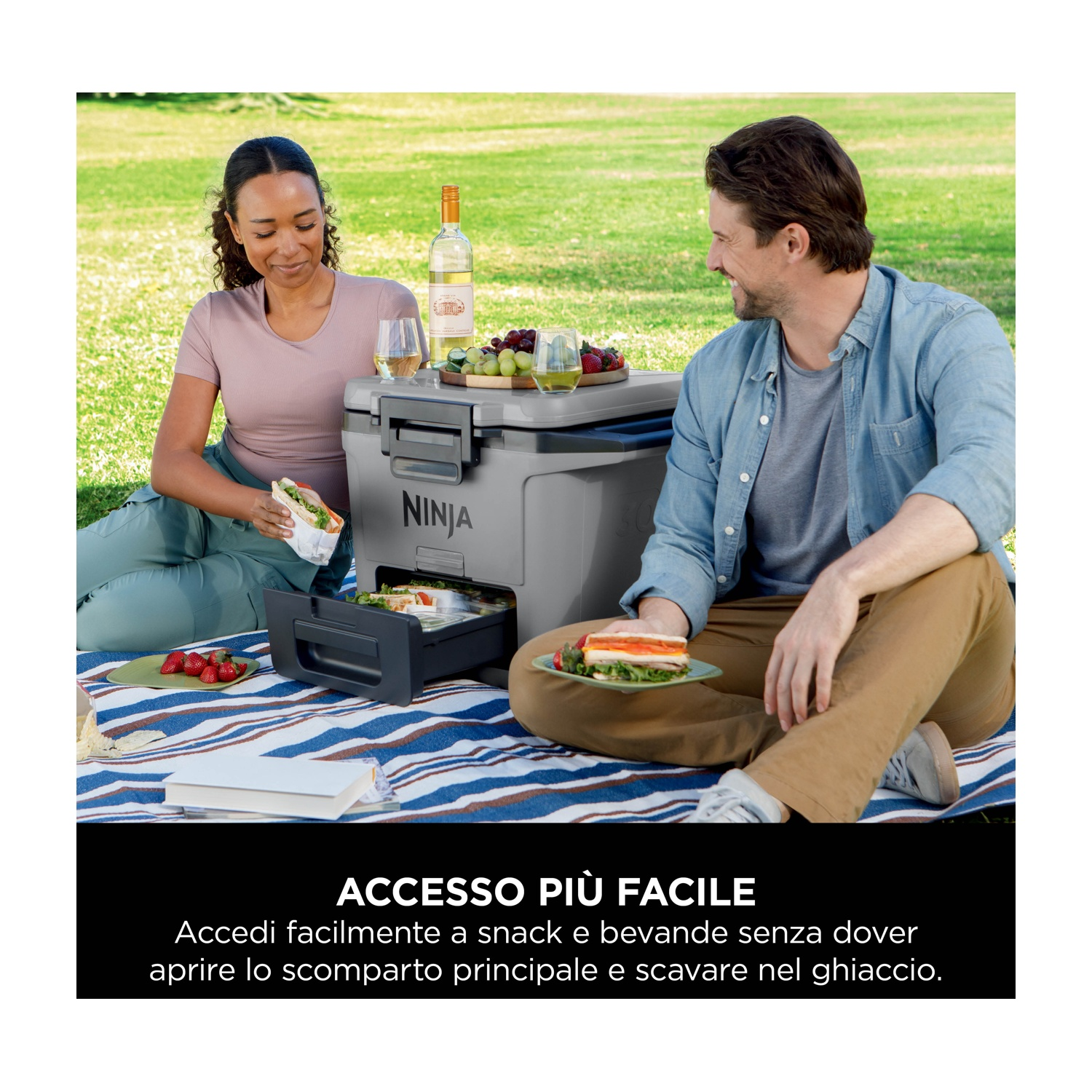 Un uomo e una donna a un picnic, con una borsa frigo e un cassetto di cibo visibili.