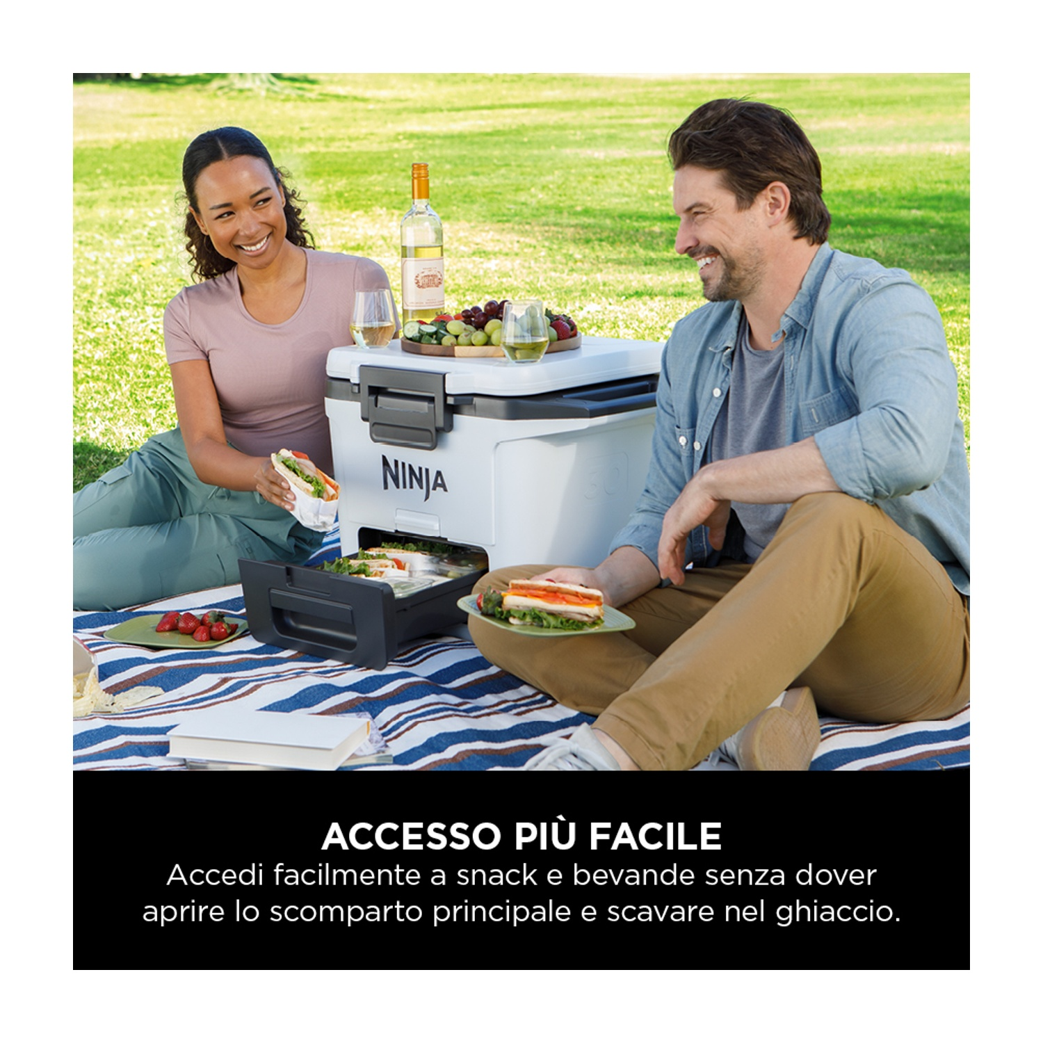 Coppia che fa un picnic vicino a un frigorifero bianco. Cibo e bevande visibili sul tavolo.