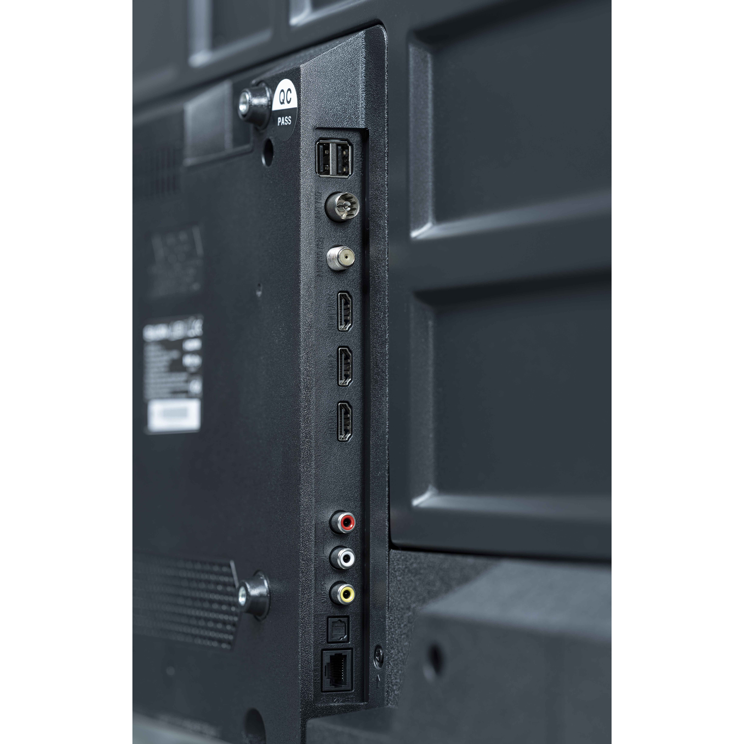 Close-up of the back of a black TV. Shows ports for USB, HDMI, and other connections.
