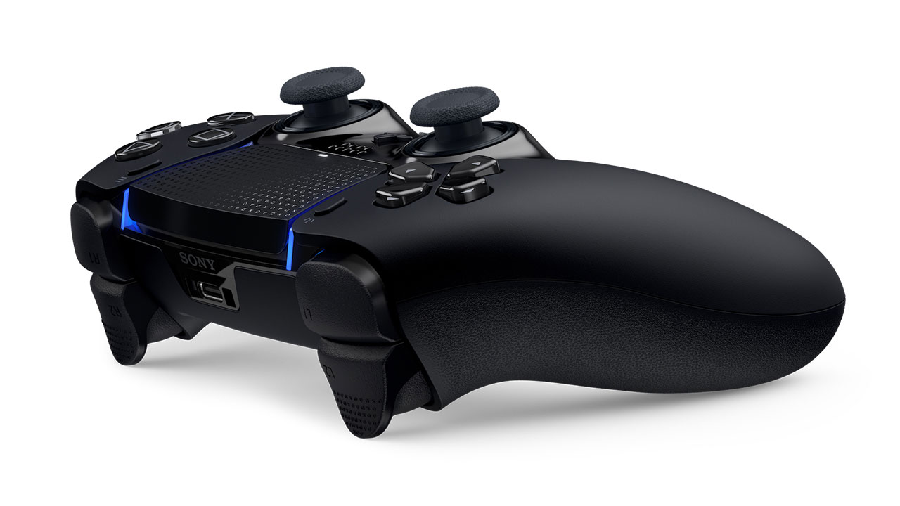 Un mando negro de Sony PlayStation sobre una superficie blanca.