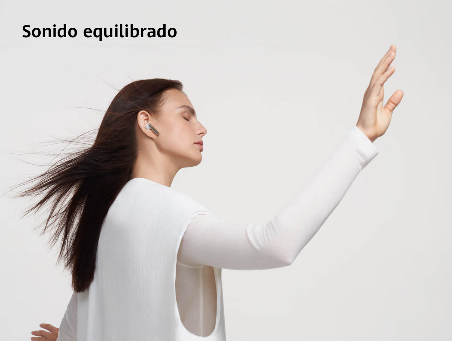 Mujer con auriculares, levantando el brazo. Texto: Sonido equilibrado.