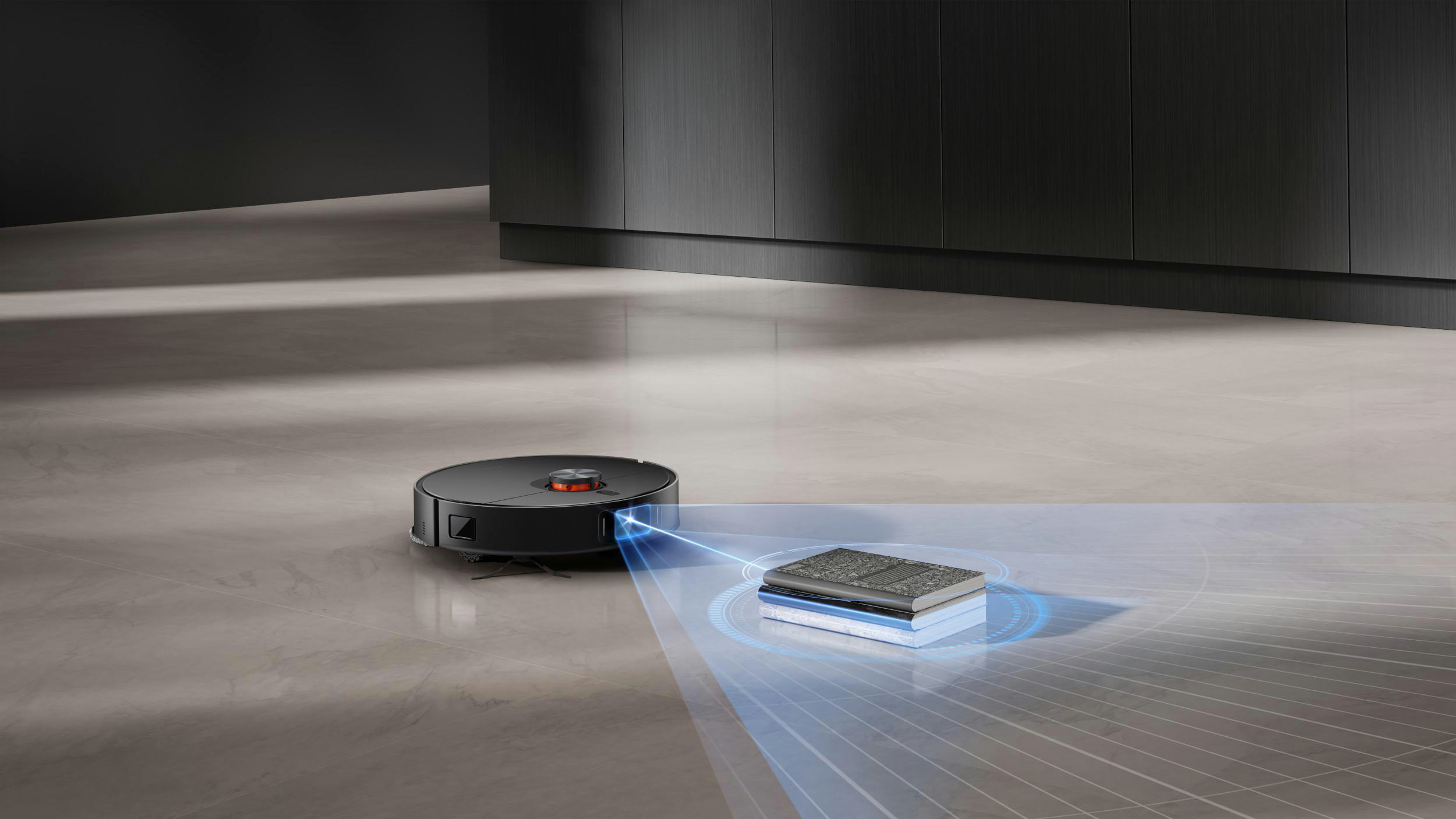 Schwarzer Roboter-Staubsauger scannt Bücher auf dem Boden. Dunkelgraue Schränke und Boden. Blaue Lichtstrahlen vom Staubsauger zu den Büchern.
