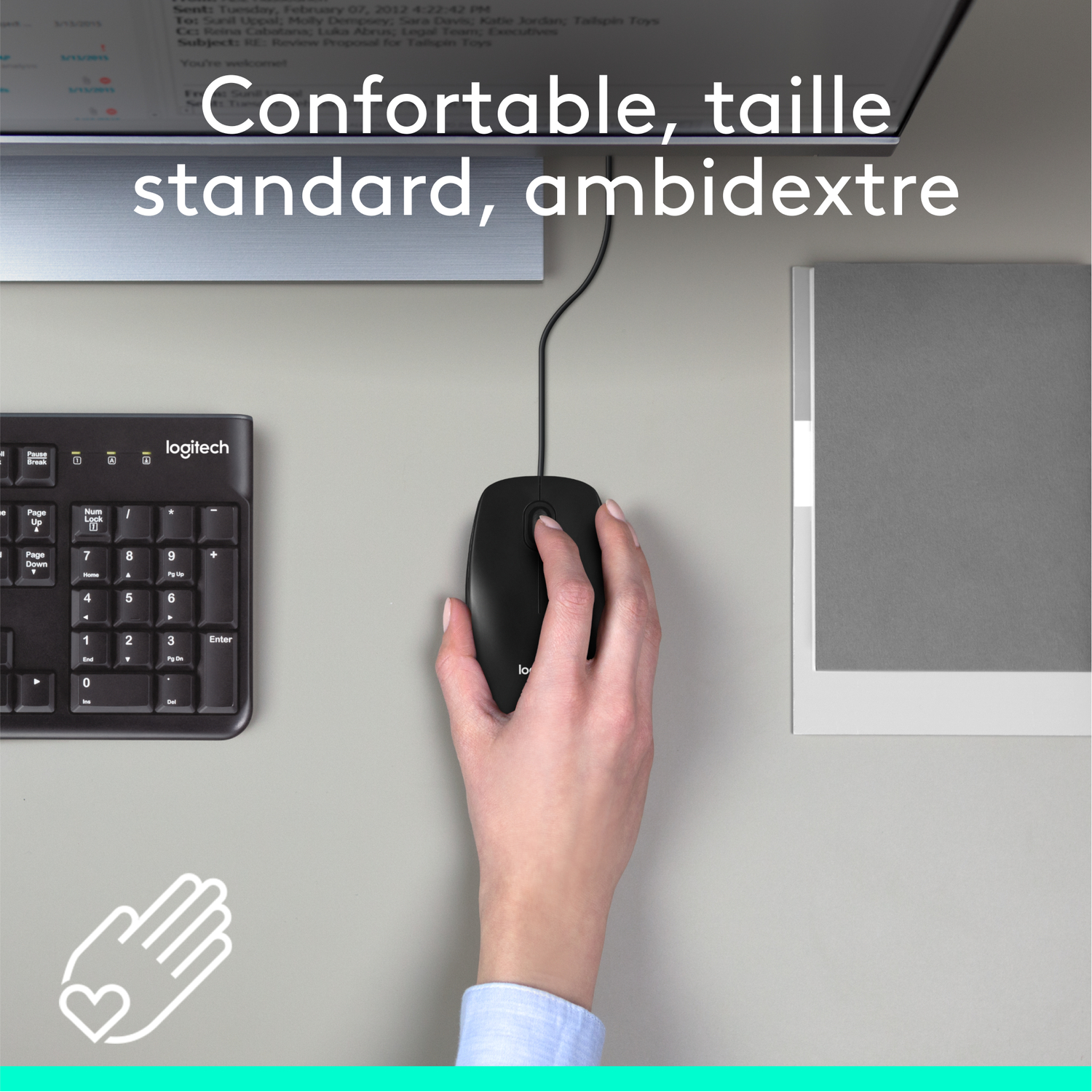 Main utilisant une souris noire, le clavier est à gauche, un moniteur en haut.