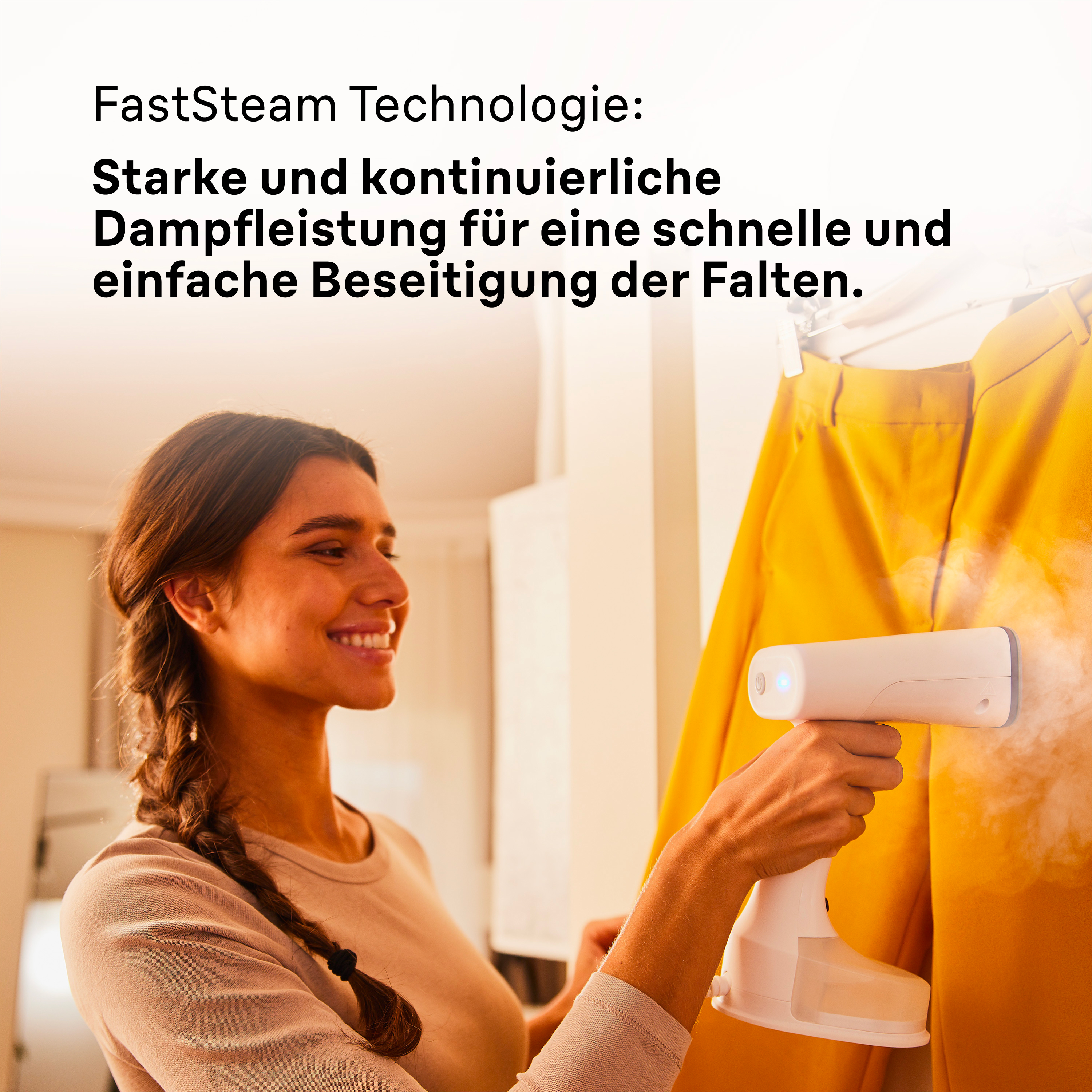 Eine Frau lächelt, während sie gelbe Kleidung dämpft. Der Steamer ist weiß.