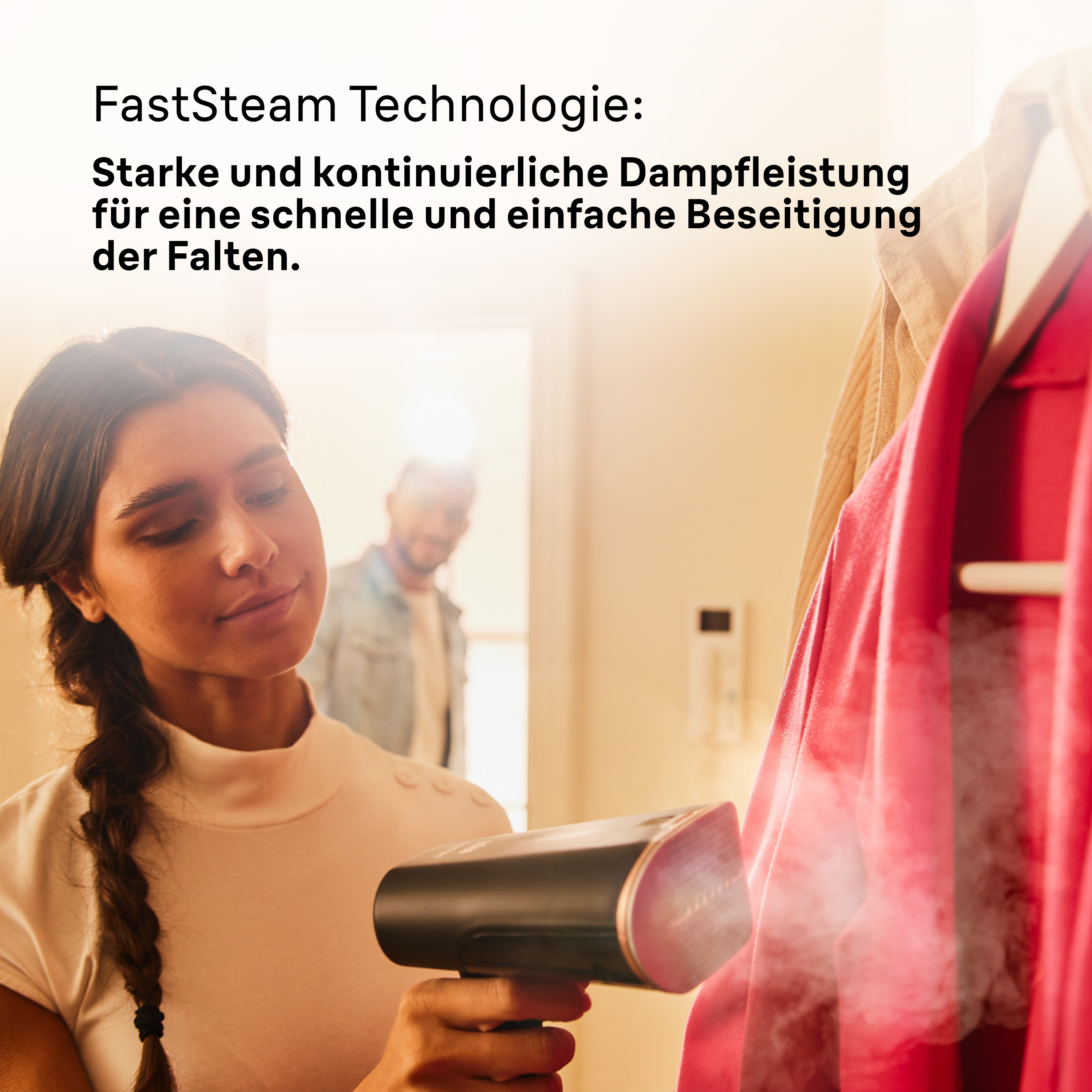 Frau dampft mit einem Handdampfer eine rote Jacke, Text über FastSteam-Technologie.
