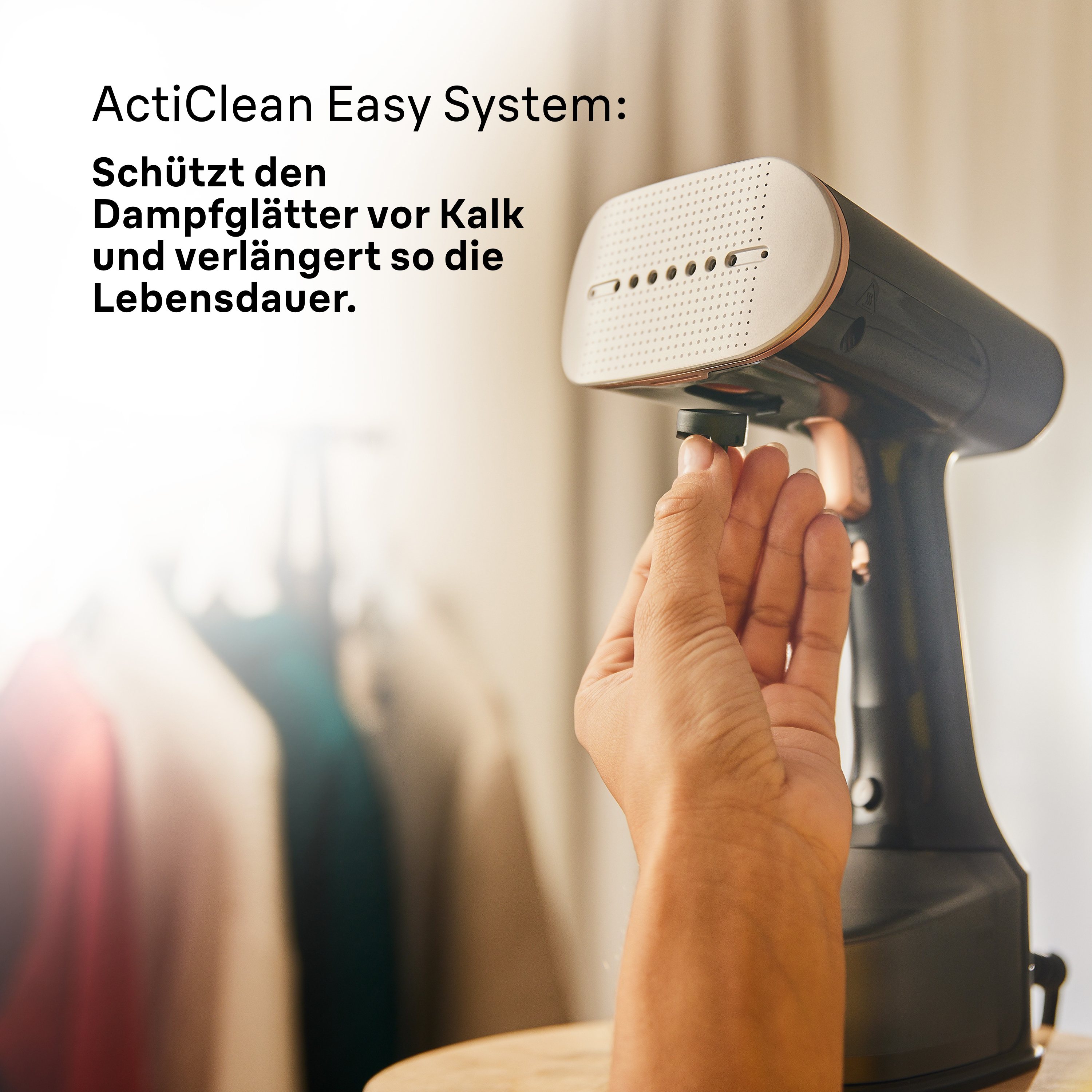 Hand hält ein schwarz-weißes Dampfbügeleisen.