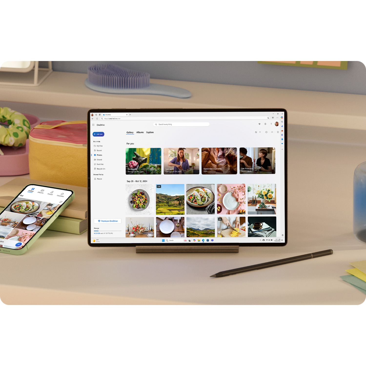 Tablet en telefoon tonen een webpagina. Een borstel en een gele tas liggen op het bureau. Er ligt een pen in de buurt.
