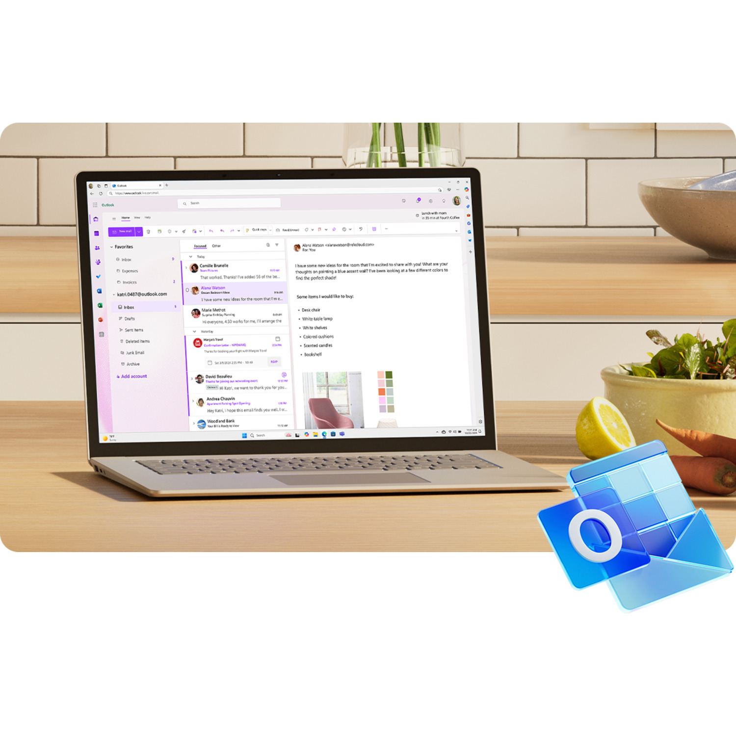 Ordinateur portable sur une table en bois affichant un e-mail. Il y a des fruits et le logo Outlook.
