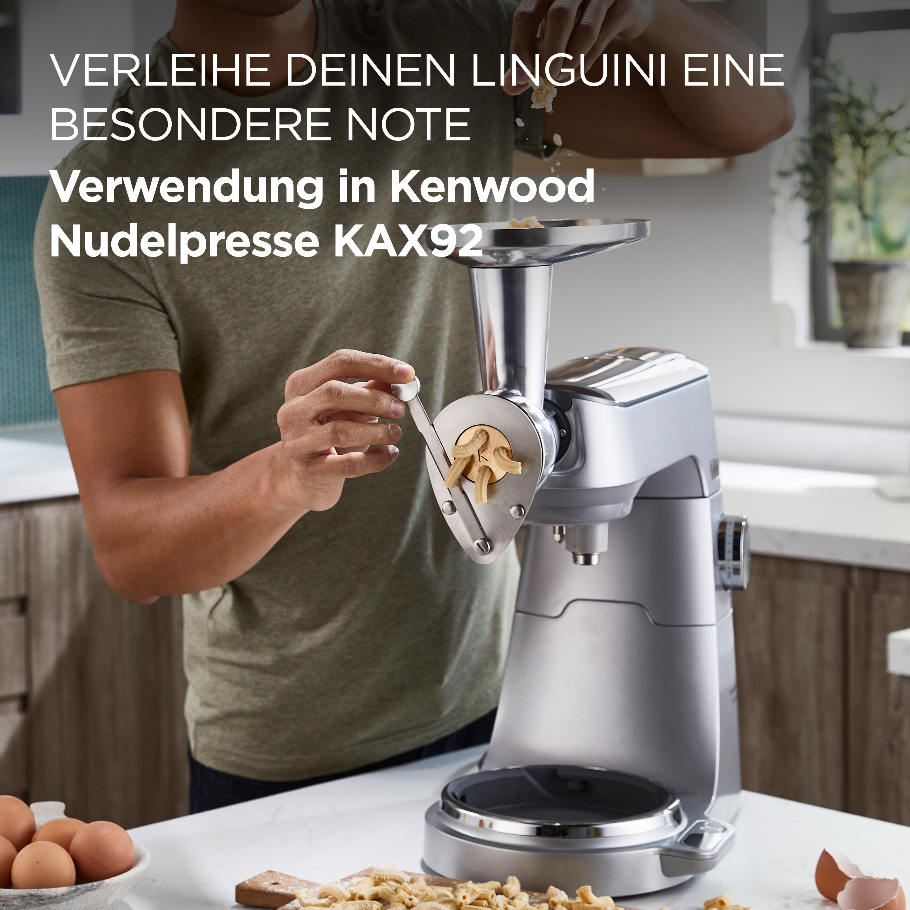 Eine Person, die Zutaten zu einer Kenwood-Nudelmaschine hinzufügt.