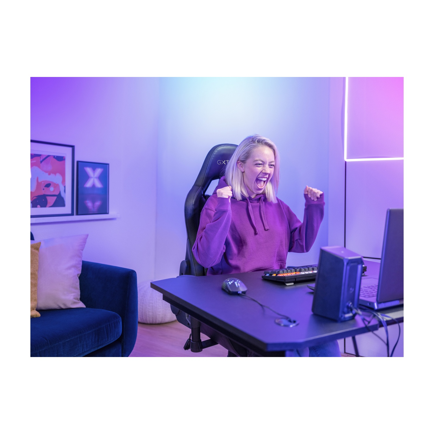 Donna che festeggia in una sala giochi, con una configurazione computer.