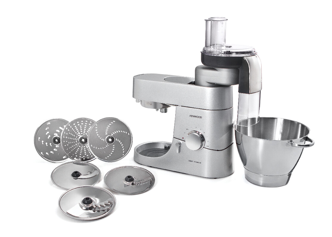 Ein Kenwood-Küchengerät mit mehreren Messern und einer Schüssel. Die Maschine ist grau und weiß.